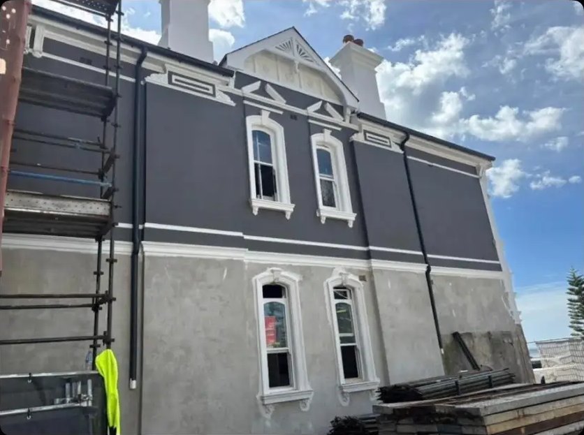 Heritage two-storey facade being rendered from scaffolding