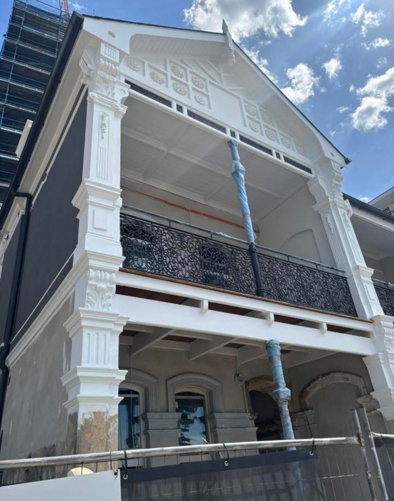Building facade with ornate pillars and balcony completed by SS Rendering